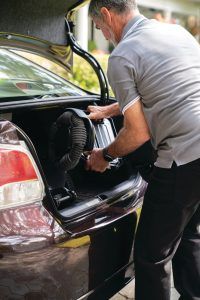 persona guardando la silla eléctrica WHILL Model C2 en el maletero