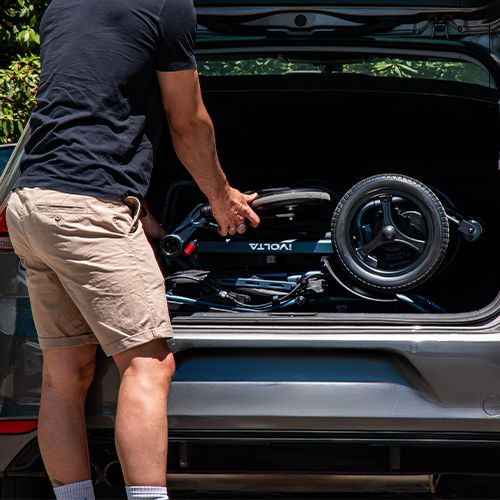 Silla de ruedas eléctrica iVolta plegada en el maletero de un coche