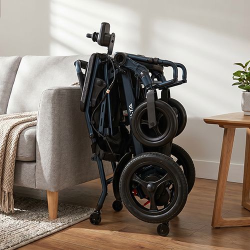Silla de ruedas eléctrica iVolta plegada junto a un sofá