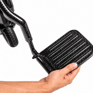 Mano levantando el reposapiés abatible de fibra de carbono de la silla eléctrica Martinika Carbon Evo