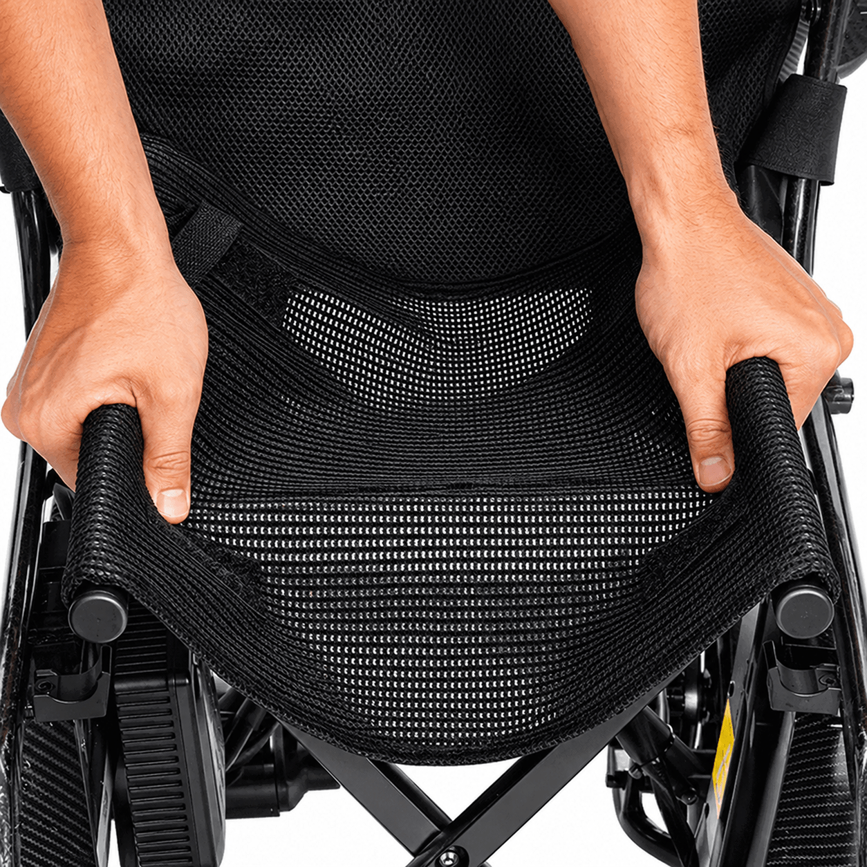 Persona plegando el asiento de la silla eléctrica Martinika Carbon Evo mediante su sistema de cierre central